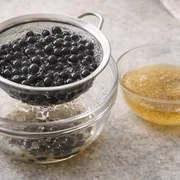 Perlen werden in Zuckersirup gegeben