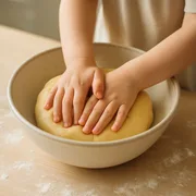 Kinderhände kneten Plätzchenteig in einer Schüssel
