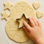 Kinderhand sticht Sterne aus dem Teig