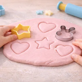 Kinderhände mit Ausstechförmchen auf Softknete